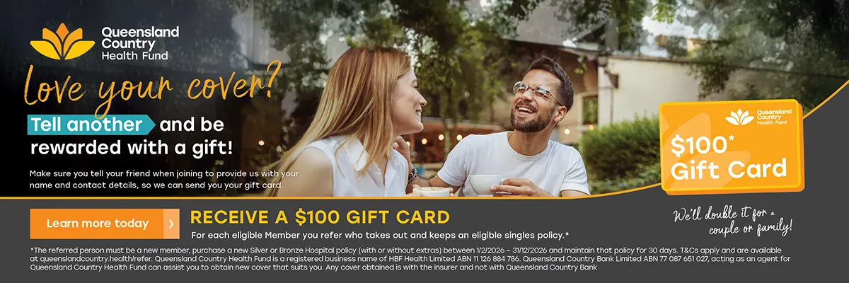 Two people sitting outdoors talking over drinks with ‘Queensland Country Health Fund’ promotion offering a $100 gift card for referrals.